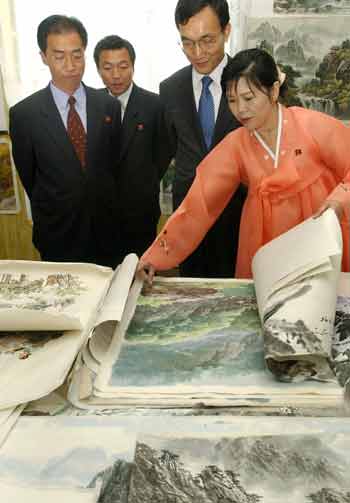 South Korea's Vice Unification Minister Rhee Bong-jo (2nd R) and North Korea's head of delegation Kim Man-gil (L) visit a North Korean folk art shop in between talks in the North Korean city of Kaesong May 16, 2005. [Reuters]