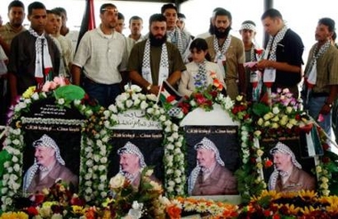 Palestinian former prisoners pay their respects at the grave of the late Palestinian leader Yasser Arafat at his former headquarters in the West Bank city of Ramallah, Thursday June 2, 2005.