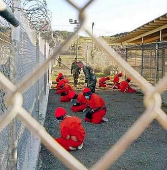 President Bush left the door open to an eventual closing of the U.S. detention center at Guantanamo Bay on Wednesday amid mounting complaints and calls for it to be shut down, including a broadside from former president and human rights champion Jimmy Carter. A file photo, dated January 11, 2002, shows detainees sitting in a holding area watched by military police at Camp X-Ray inside Naval Base Guantanamo Bay, Cuba, during their processing into the temporary detention facility. Photo by Reuters International USA said on Sunday the group doesn't 'know for sure' that the military is running a 'gulag.' REUTERS