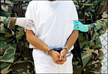 A detainee is escorted by military police at Camp 4 of the maximum security prison Camp Delta at Guantanamo US Naval Base, in Guantanamo, Cuba in 2004.