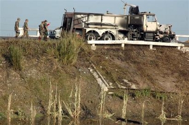 Mexican army soldiers pass a destroyed truck after a gas pipeline explosion occurred near the town of Huimango, about 385 miles (620 kilometers) east of Mexico City, Mexico on Saturday July 9, 2005. 