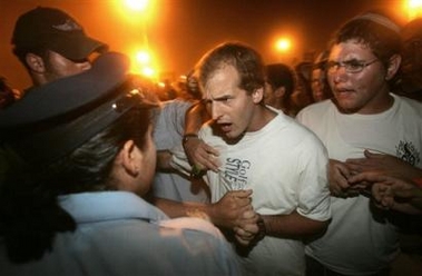Jewish settlers confront Israeli police as settlers and protesters block the Kissufim crossing point into the Gush Katif bloc of settlements in the southern Gaza Strip late Wednesday, July 13, 2005.
