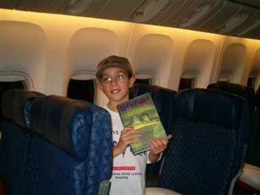 This image made available by Scholastic Books shows James Traver, 11, from Vancouver, Washington, one of ten national winners of the Scholastic Harry Potter Essay Contest, posing with his free copy of Harry Potter and the Half-Blood Prince onboard American Airlines flight AA12 in New York at 12:01 A.M. EST Saturday July 16, 2005 to read on the overnight flight to London. (AP
