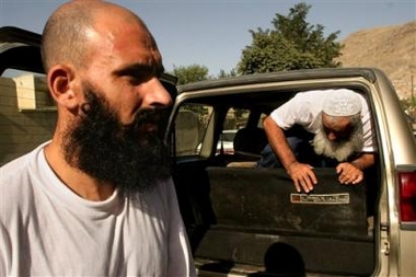Former Afghan Guatanamo prisoners Moheb Ullah Borekzai, left, and Habir Russol, right, get out of the car that took them to their release ceremony in Kabul, Afghanistan, Wednesday, July 20, 2005. The two Afghans released Wednesday after being detained at Guantanamo Bay in Cuba claimed that about 180 other Afghans held at the U.S. detention facility were on a hunger strike to protest alleged mistreatment and to push for their release. (AP