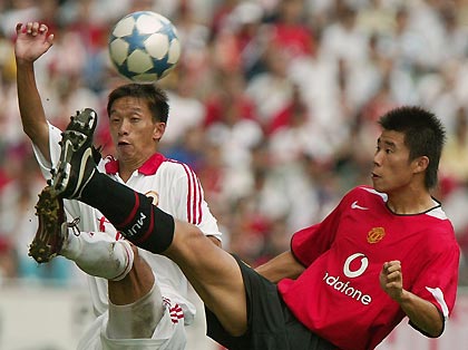 Manchester United's Chinese player Dong Fangzhou (R) and Hong Kong's Poon Yiu-cheuk fight for the ball in Hong Kong July 23, 2005. The English Premier League team beat Hong Kong 2-0, with Dong scoring the second goal, during their match on Saturday as part of their Asian tour to China and Japan.