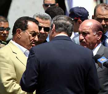 Egypt's President Hosni Mubarak (L) listens to top officials as he tours the bombed areas in the Red Sea resort of Sharm el-Sheikh in Egypt July 23, 2005.
