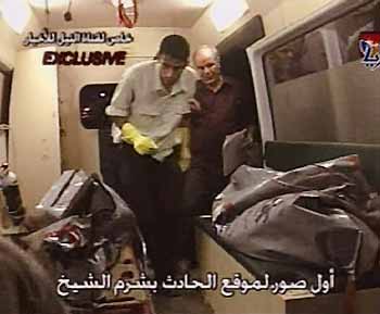 Video grab from Egyptian television El Masriya and Nile TV shows people walking among body bags inside an ambulance after a blast in Sharm el- Sheikh, July 23, 2005.