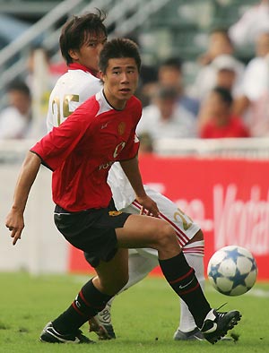 Manchester United's Chinese player Dong Fangzhou (front) is followed by Hong Kong's Li Hang-wui during the second half of their match in Hong Kong July 23, 2005. The English Premier League team beat Hong Kong 2-0, with Dong scoreing the second goal, during their match on Saturday as part of their Asian tour to China and Japan.