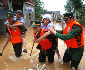 Armed police officers carry two senior villagers to safety in Suzhou, East China's Anhui Province August 3, 2005. Many villages were flooded in the city due to heavy rainfalls. [newsphoto]