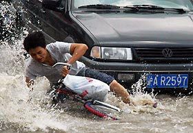 Heavy rainwater on the street in Shanghai makes riding tough. NIE YIXIN