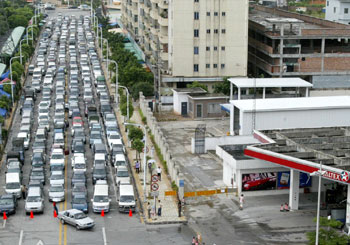Cars line up to buy petrol at a petrol station in Dongguan, south China's Guangdong province, August 17, 2005. [newsphoto]