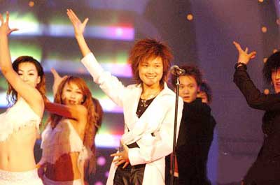 Li Yuchun sings and dances at the 2005 Super Girl contest finals in Changsha, Hunan Province August 27, 2005. Li got more than 3.52 million votes in support of her. Zhou Bichang, the second place winner, and Zhang Liangying, the third place winner, received more than 3.27 million and 1.35 million votes respectively. [Xinhua]