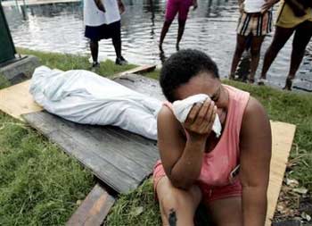 Evelyn Turner cries alongside the body of her common-law husband, Xavier Bowie, after he died in New Orleans, Tuesday, Aug. 30, 2005. Bowie and Turner had decided to ride out Hurricane Katrina when they could not find a way to leave the city. Bowie, who had lung cancer, died when he ran out of oxygen Tuesday afternoon. [AP]