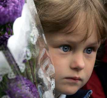 A Russian schoolgirl stands with flowers in front a Moscow school on the first day of a new school year, September 1, 2005. 