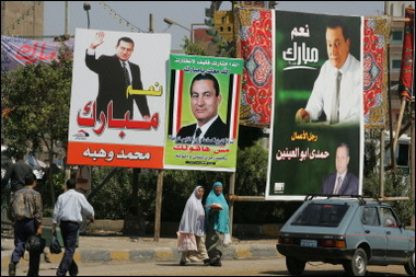 Egyptians walk past electoral posters and billboards promoting Egyptian candidate and current President Hosni Mubarak in Cairo.