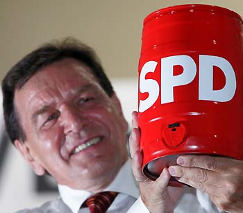 Germany's Chancellor Gerhard Schroeder smiles as he holds a beer barrel during an election campaign rally for Germany's Social Democratic Party (SPD) in the southern German town of Kulmbach September 7, 2005. German elections will be held on September 18, one year ahead of schedule, after the country's highest court ruled the early vote engineered by Chancellor Schroeder was legal. [Reuters]