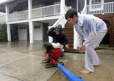 Norman Chambliss, left, and his son Yates, right, try to start a pump to remove water from outside his home at Wrightsville Beach, N.C., Wednesday, Sept. 14, 2005, as Hurricane Ophelia threatened the North Carolina coast. (AP