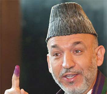 Afghan president Hamid Karzai shows his inked-finger before voting in Kabul, Afghanistan on Sunday. (AP