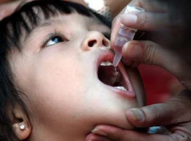 An Indonesian child receives polio drops during a mass polio vaccination in Jakarta September 27, 2005. Indonesia on Tuesday kicked off the second round of a nationwide campaign to immunise more than 24 million children in a bid to stop the spread of polio in the world's fourth most populous country.