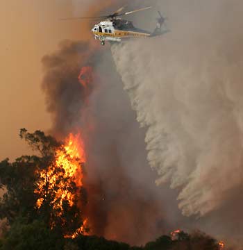 Los Angeles County Fire Department helicopter makes a water drop in the West Hills area of Los Angeles September 29, 2005. More than 16,000 acres have burned and hundreds of people have been evacuated as more than 3,000 firefighters battle the wind-whipped blaze. [Reuters]