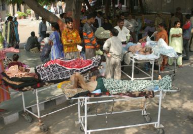 Patients and their attendants wait outside a hospital after an earthquake hit the northern Indian city of Jammu, October 8, 2005.