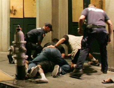 Police officers subdue a man on Conti Street near Bourbon Street in the French Quarter of New Orleans Saturday night, Oct. 8, 2005.