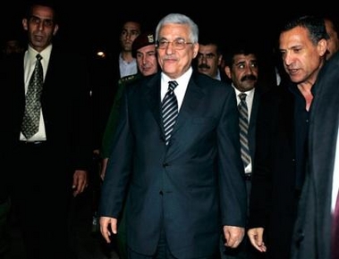 Palestinian Authority President Mahmoud Abbas, also known as Abu Mazen, flanked by his aides, talks to reporters outside his house in the West Bank city of Ramallah, Sunday, Oct. 9, 2005.