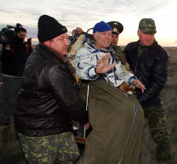 Ground personnel carry U.S. space tourist Gregory Olsen after his landing near the town of Arkalyk in northern Kazakhstan October 11, 2005. A Soyuz space capsule touched down safely in Kazakhstan on Tuesday, bringing a Russian-U.S. crew back to earth from the International Space Station.