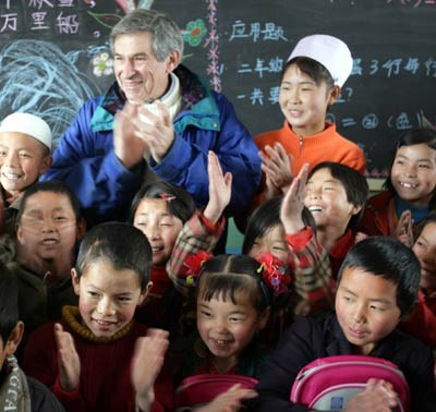 World Bank President Paul Wolfowitz poses for a photo with students of a primary school in Dongxiang County, Northwest China's Gansu Province Thursday October 13, 2005. Wolfowitz is inspecting some of World Bank's loan projects concerning poverty alleviation and education in China. [newsphoto]