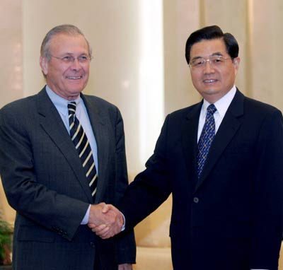 Chinese President Hu Jintao (R) shakes hands with visiting US Defense Secretary Donald Rumsfeld inside the Great Hall of the People in Beijing October 19, 2005. [newsphoto]