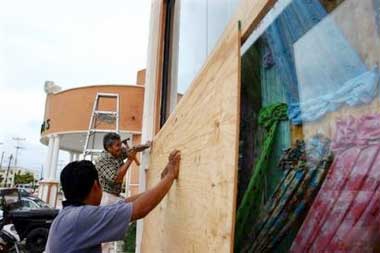 Workers cover storefront windows with wood in Playa del Carmen in the Yucatan peninsula, Mexico, Wednesday, Oct. 19, 2005. Hurricane Wilma rapidly strengthened into one of the Americas' most intense storms ever and lashed Caribbean coastlines Wednesday, forcing tourists to flee as it threatened to slam into Cancun and southern Florida. (AP