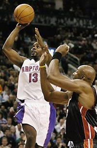 Toronto Raptors Mike James, left, drives to the basket against Miami Heat's Alonzo Mourning during first half NBA action in Toronto, Sunday Nov. 20, 2005.