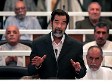 Saddam Hussein speaks to the Presiding Judge Rizgur Ameen Hana al-Saedi as his trial begins in a heavily fortified courthouse in Baghdad's Green Zone in this October 19, 2005 file picture.