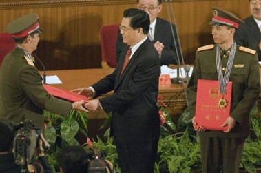 Chinese astronaut Fei Junlong, right, looks on as Nie Haisheng, left, receives an award from Chinese President Hu Jintao during a ceremony to mark the successful conclusion of last month's Shenzhou 6 manned mission at the Great Hall of the People in Beijing, China, Saturday, Nov. 26, 2005.