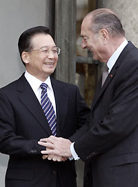 French President Jacques Chirac (right) greets Premier Wen Jiabao on the steps of the Elysee Palace in Paris yesterday. Wen is on the second day of a four-day visit to France. 	