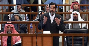 Former Iraqi president Saddam Hussein (C, front) addresses the court during a trial in Baghdad, December 6, 2005.