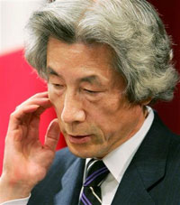 Japanese Prime Minister Junichiro Koizumi scratches his face as he talks to reporters at the premier's official residence in Tokyo December 8, 2005. 