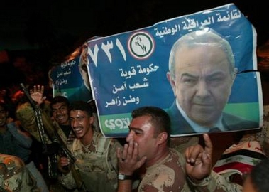 Iraqi soldiers hold election campaign posters for the Iraqi National list carrying pictures of the head of the list, Shiite secular leader and former Prime Minister Ayad Allawi while receiving released prisoners in Baghdad, Iraq Sunday, Dec. 11, 2005.