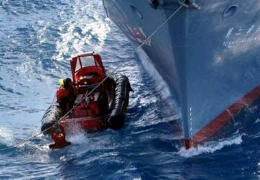 A Greenpeace activist grabs the rope from a harpoon as he tries to get back aboard an inflatable boat after a harpoon fired from a Japanese whaling ship narrowly missed them in the Southern Ocean January 14, 2006. 