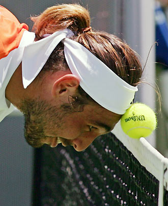 Marcos Baghdatis of Cyprus traps the ball between his head and the net during his match against Radek Stepanek of the Czech Republic at the Australian Open tennis tournament in Melbourne January 18, 2006. [Reuters]