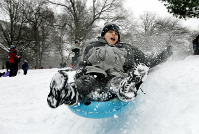 A boy goes sledding in New York's Central Park during a snowstorm February 12, 2006. The biggest snowstorm of the season belted the northeastern United States on Sunday with whiteout conditions and flashes of lightning, forcing airports to close, snarling traffic and bringing joy to ski resorts. As much as 22.8 inches (57.9 cm) of snow fell in New York's central park, the second heaviest snowfall on record, topped only by a blizzard in 1947, said the National Weather Service. 