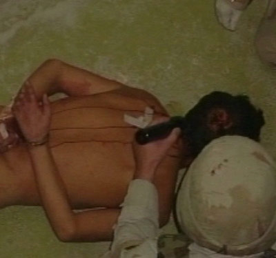 A TV frame grab shows an image made available by Australia's Special Broadcasting Service (SBS) on February 15, 2006, of what the broadcaster says is a detainee being abused in Iraq's Abu Ghraib prison taken in 2003.[Reuters]
