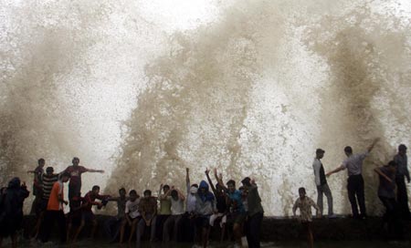 Huge waves crash on a seaside promenade during heavy rain in India's financial capital Mumbai June 1, 2006. India's commercial capital of Mumbai was on alert for very heavy rains on Thursday, almost a year after a sharp cloudburst crippled the metropolis for days and killed hundreds of people in the region. 