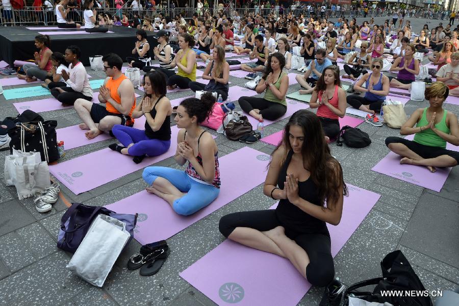 People practice yoga in Times Square to mark Summer solstice day