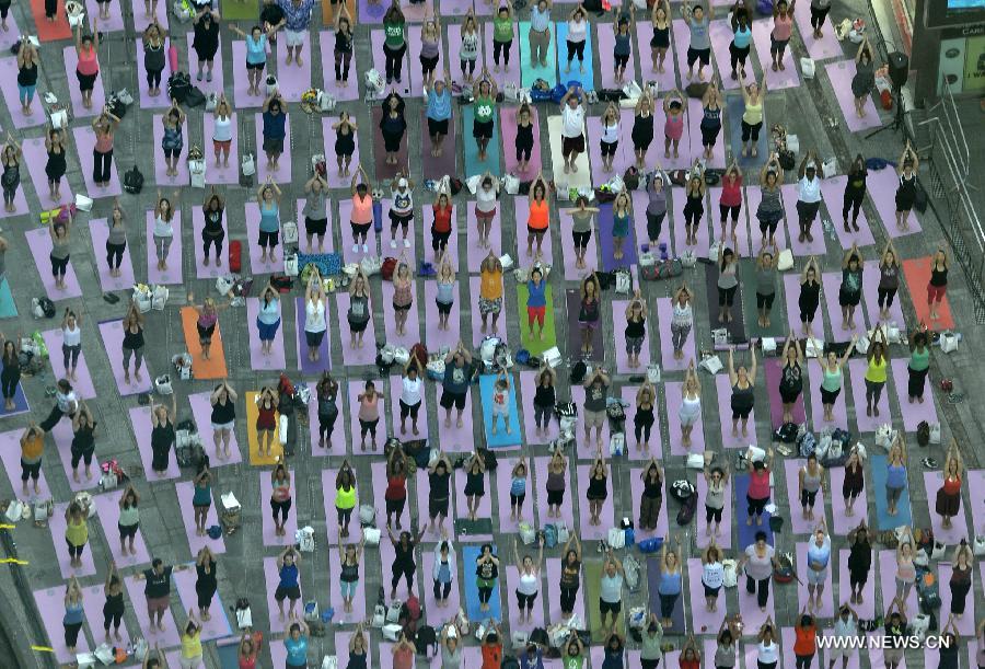 People practice yoga in Times Square to mark Summer solstice day