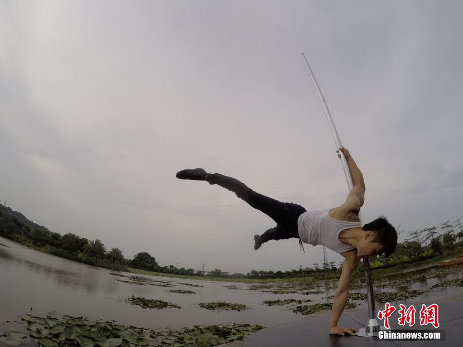 Male pole dancer shows strength and beauty