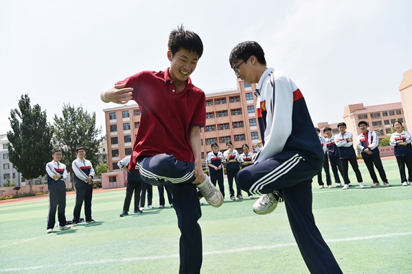 1716541015124054604.jpg 9-2024年5月22日,在山东潍坊高密市第五中学,高三学生在玩“斗拐”游戏。(李海涛 摄)_副本.jpg
