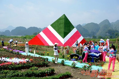 Tourists have fun with straw sculptures in Xingyi