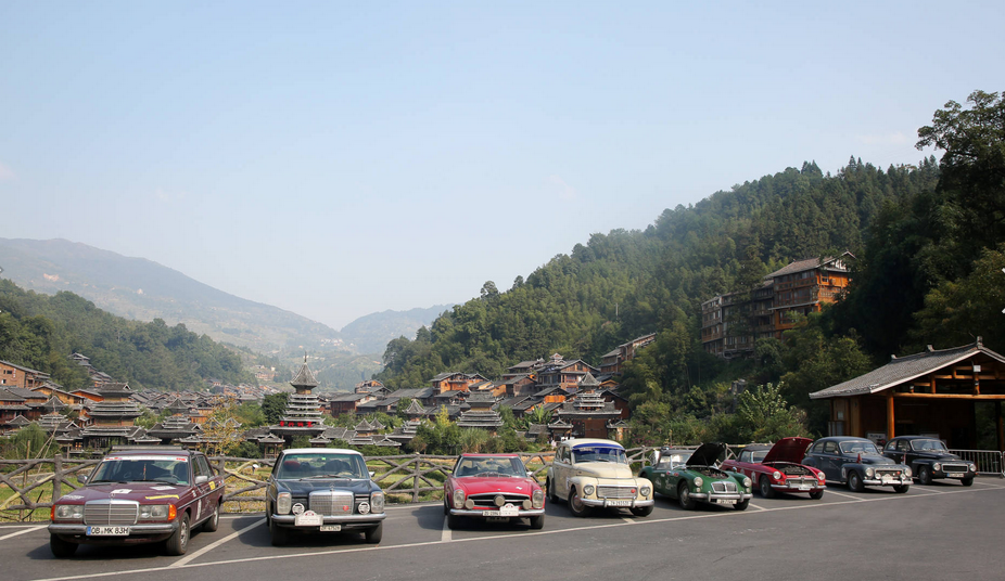 Fleet of vintage cars arrives in Zhaoxing Dong village, Guizhou province during cross-country trip
