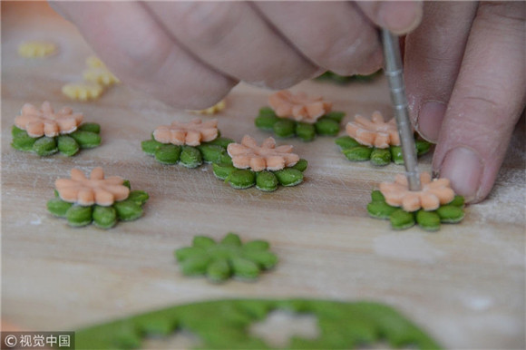 Artisan makes flower cakes for Chinese New Year